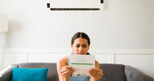Spring Hill Florida homeowner adjusting thermostat to improve HVAC energy efficiency