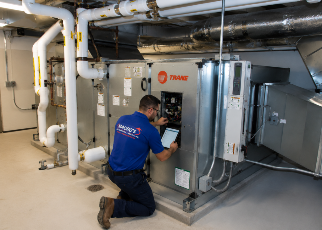 Commercial HVAC technician performing preventative maintenance on a Trane air handling unit