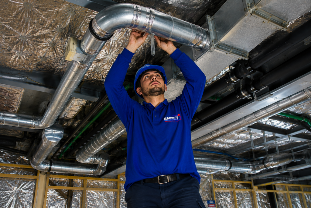 Mauro's Air technician installing commercial HVAC ductwork inside a commercial building