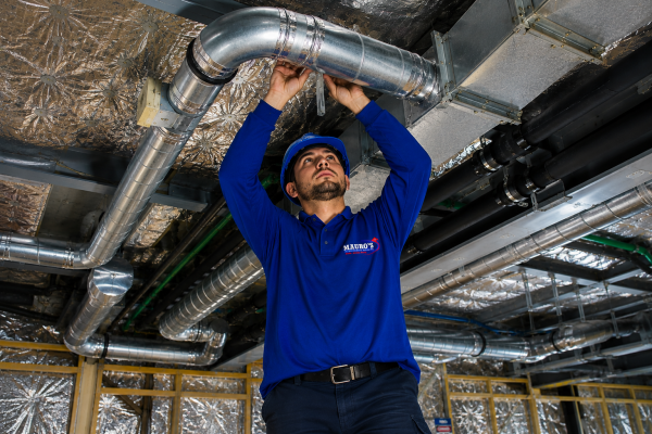 Mauro's Air technician installing commercial HVAC ductwork inside a commercial building